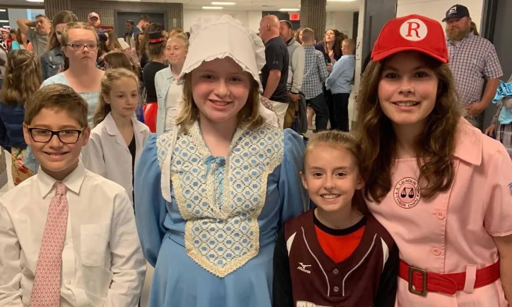 Four children smiling for the camera at the social studies fair.