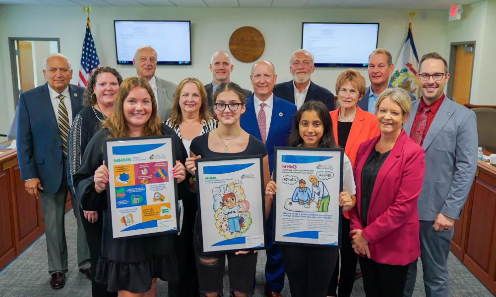 Pictured are students holding posters and posing for a photo with members of the West Virginia Board of Education 