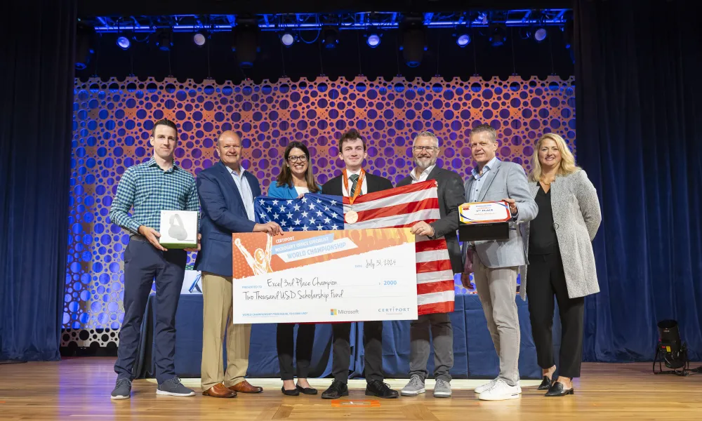 Pictured is Andrew Manteau receiving a third place prize while holding an American flag.