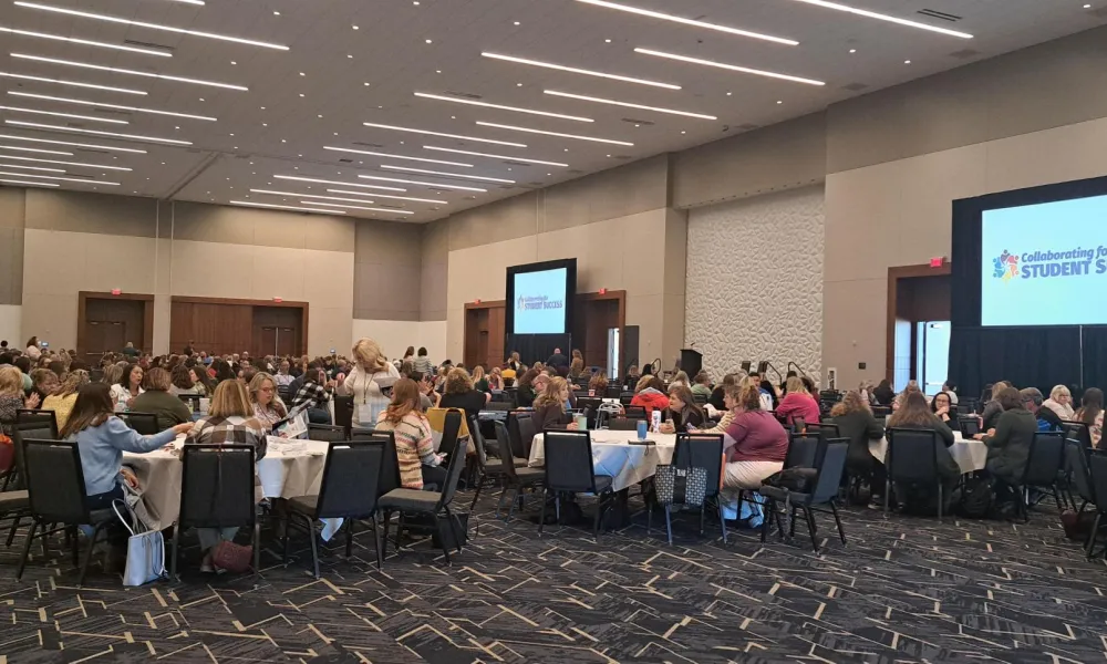 Student Support Conference attendees gather at tables in a large auditorium.