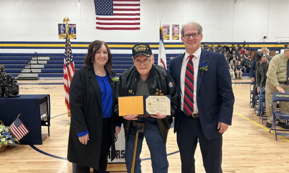 Clay County Board of Education President Phoebe Nichols, World War II Veteran Charles Bird and Clay County Superintendent Phil Dobbins pose for a photo with Bird’s high school diploma.