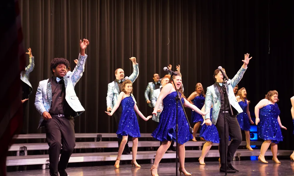 Students on stage during a show choir performance.