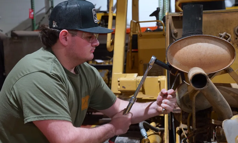 Man working on a motor with socket wrenches.