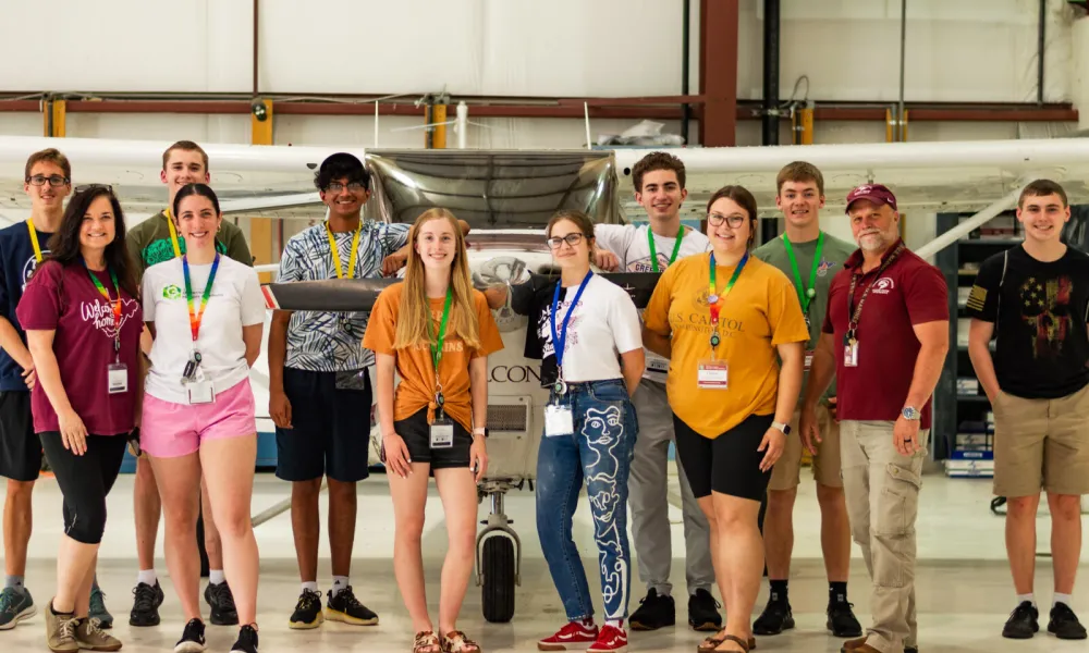 2024 Governor's Honors Academy participants standing together in airplane hangar