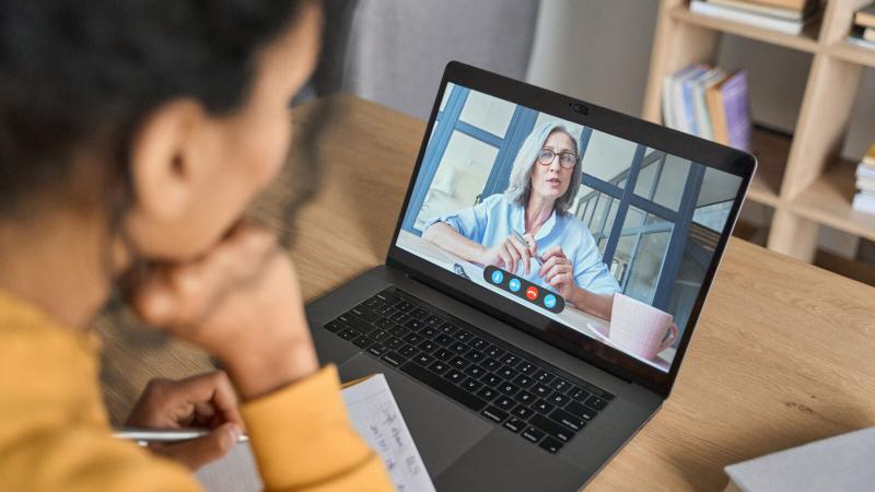 Woman speaking to another person on a laptop using a webcam.