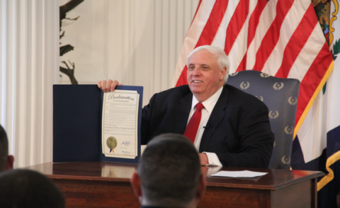 Governor Jim Justice holds up a signed bill