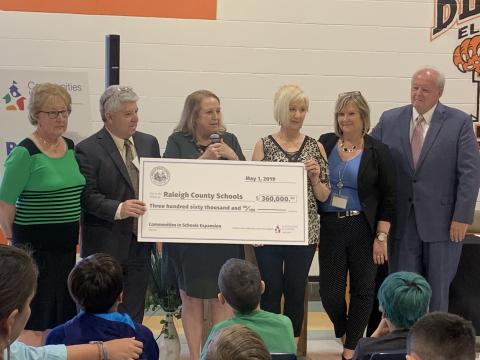 Group of people hold a large check