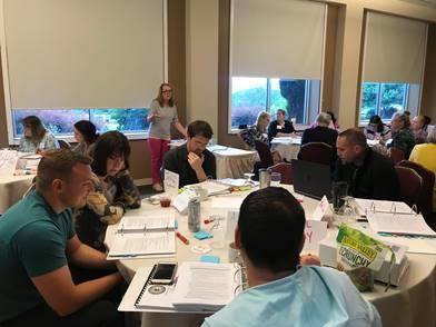 Educators sitting around a table at a National Board Certification training hosted by the WV Department of Education