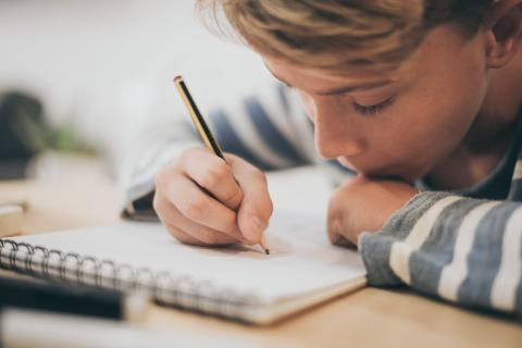 Student writing in a notebook