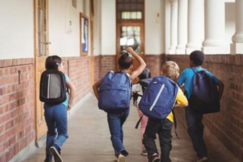 Five elementary students walking down the hallway