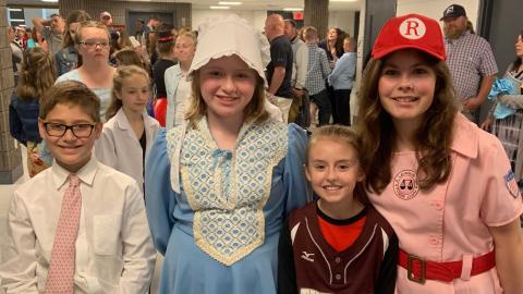 Four children smiling for the camera at the social studies fair.