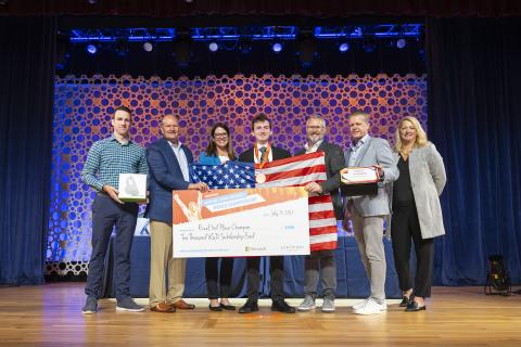 Pictured is Andrew Manteau receiving a third place prize while holding an American flag.