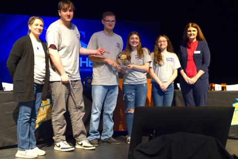 Westside High School Team 1 students posing for a group photo while holding a second-place 2024 Academic Showdown trophy.