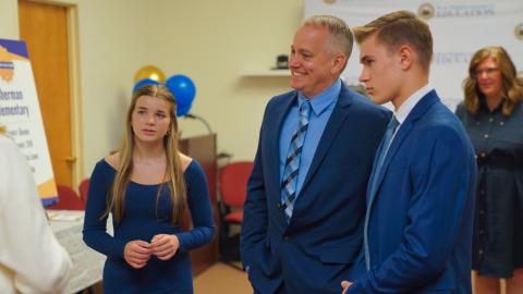 Picture from May 2024 Exemplary Practice Schools WVBE event - Three attendees listening to another person speaking (off camera)