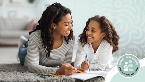 A mother and daughter are lying on the floor, smiling and drawing together.