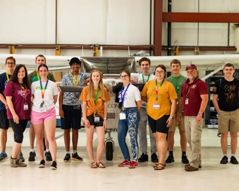 2024 Governor's Honors Academy participants standing together in airplane hangar