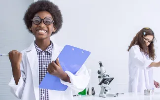 Young boy studying science in classroom at school