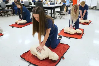 People practicing CPR on practice dummies.